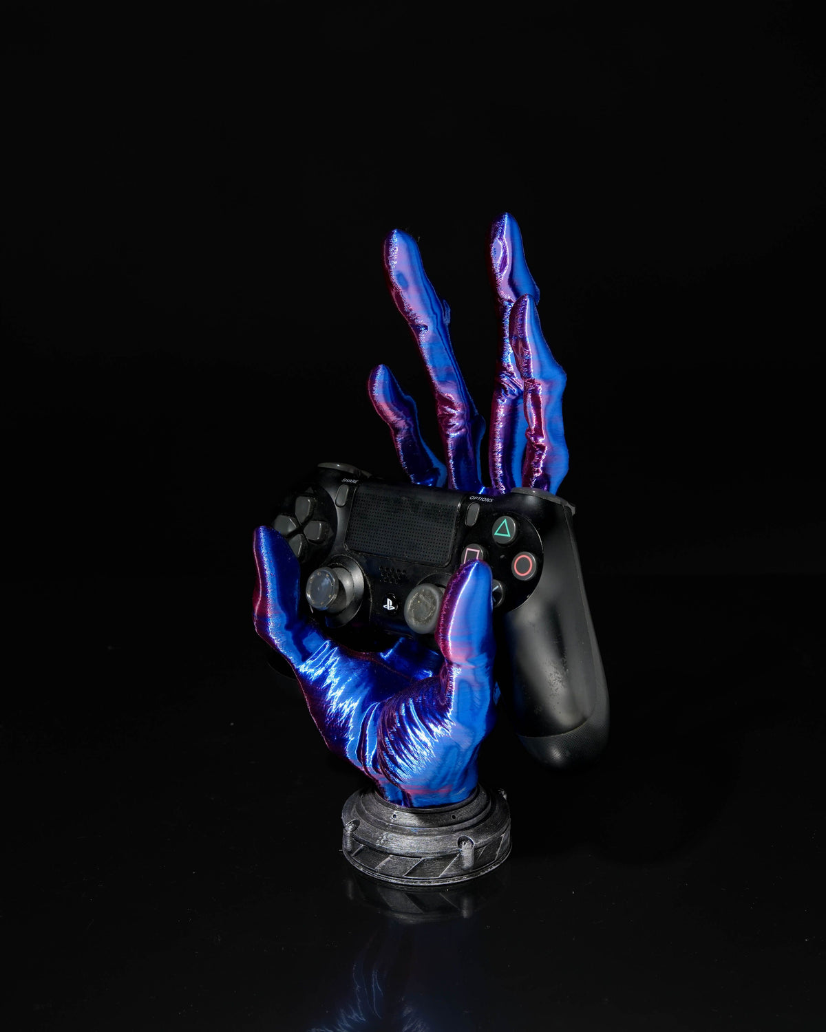 Gaming controller held by a hand with blue and purple accents on a black background